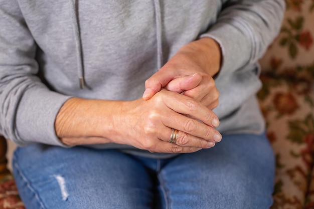 Senior woman suffering from hand and finger joint pain inflammation