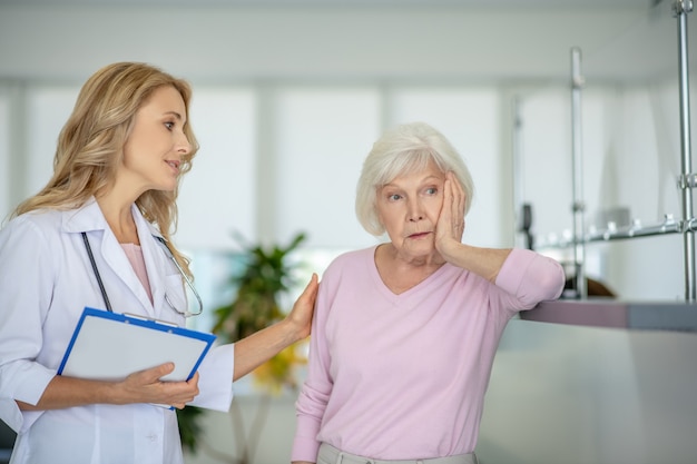 Senior woman talking with the doctor and looking frustrated