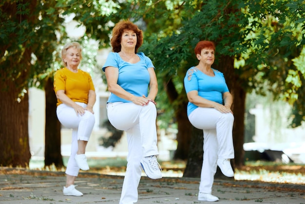 Senior woman training together in park on early sunny morning doing workout cardio exercises Concept of sport and health active lifestyle age wellness body care