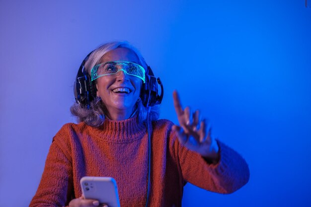 Senior woman using the technological and virtual reality glasses to experiment Concept Technology technological advances improvement