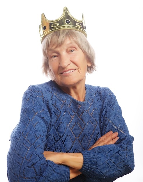 Senior woman wearing crown doing funky action isolated