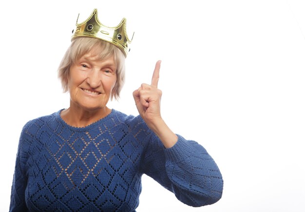 Senior woman wearing crown doing funky action isolated