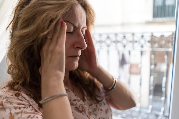 Senior woman with bedside pain sitting on the bed in her apartment copy space