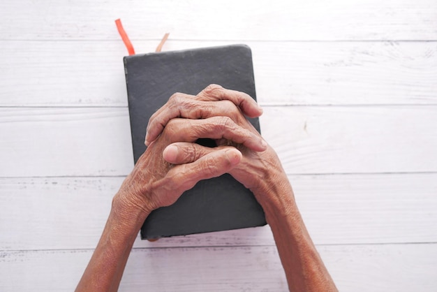 Senior women holding a bible in his hands and praying