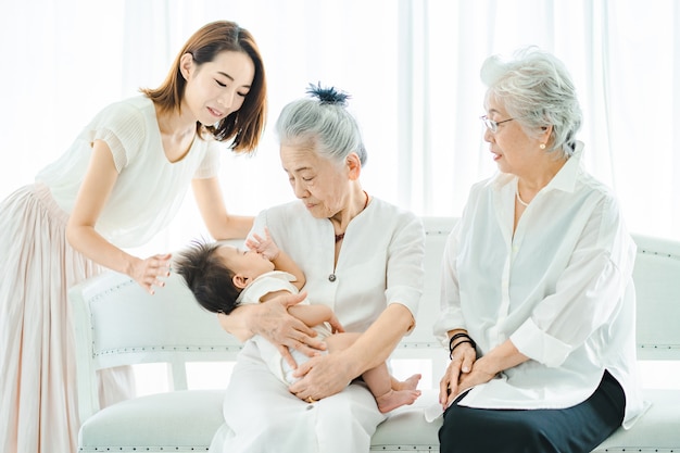 Senior women hugging babies and women watching over