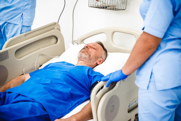 Seniour Male patient lying on a medical bed in hospital ward Uncontious man in chamber Blue medical clothes