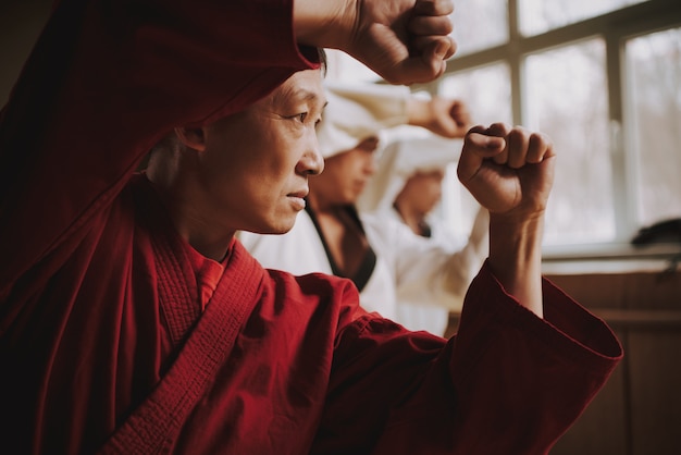 Sensei in red two martial arts students training