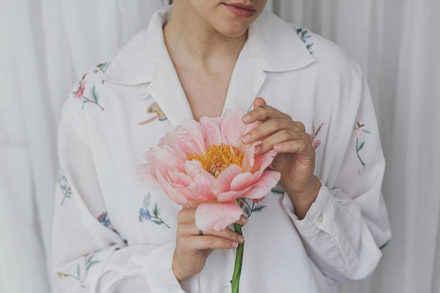 Sensual beautiful woman with pink peony in hands Tender soft image Spring aesthetics