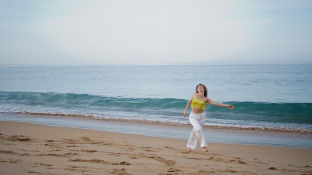 Sensual girl dancing improvisation in modern style at sand beach woman spinning