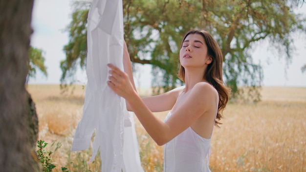 Sensual lady hanging laundry at meadow closeup romantic woman looking at camera