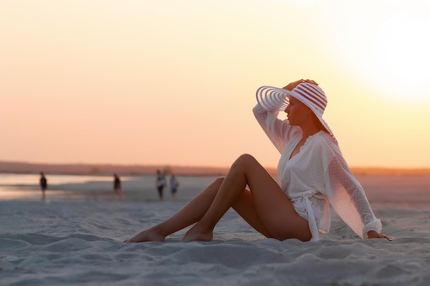 Sensual model in beachwear on sandy shore