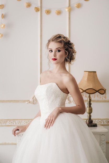 Sensual portrait of bride blonde in a white interior