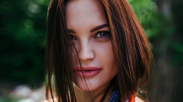 Sensual portrait of a sexy brunette girl, in the background of the forest. Close-up, look into the camera.