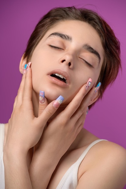 Sensual pretty girl with short haircut and extravagant nail art