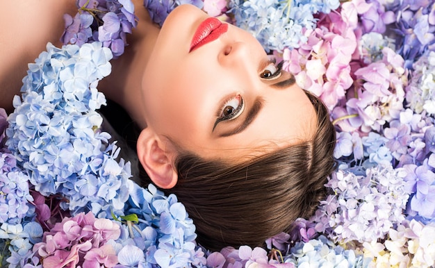 Sensual woman face in blooming hydrangea in background romantic and love concept nature beauty woman