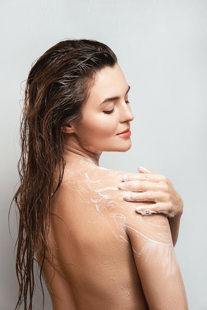 Sensual woman washing her body with shower gel