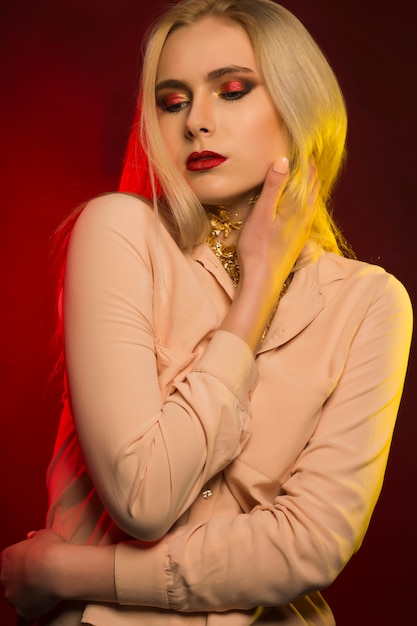 Sensual young model with bright makeup. Red and yellow studio light