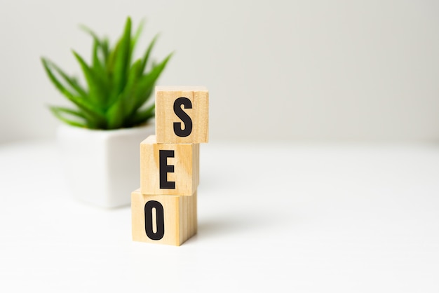 SEO - text on wooden cubes, on wooden background.