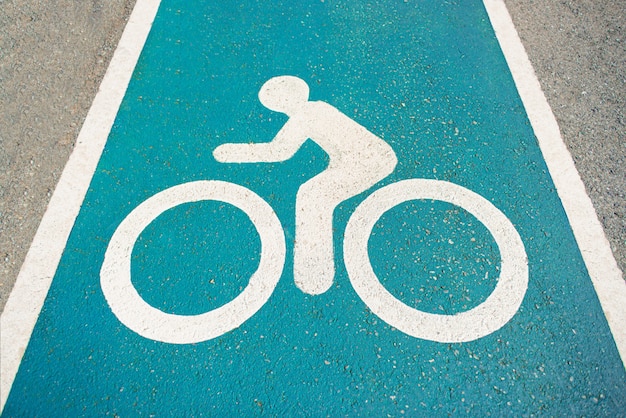 Separate bicycle lane for riding bicycles.Bicycle icon on the lane. New public asphalt bicycle lane  close up beside the road. White painted bike on asphalt.