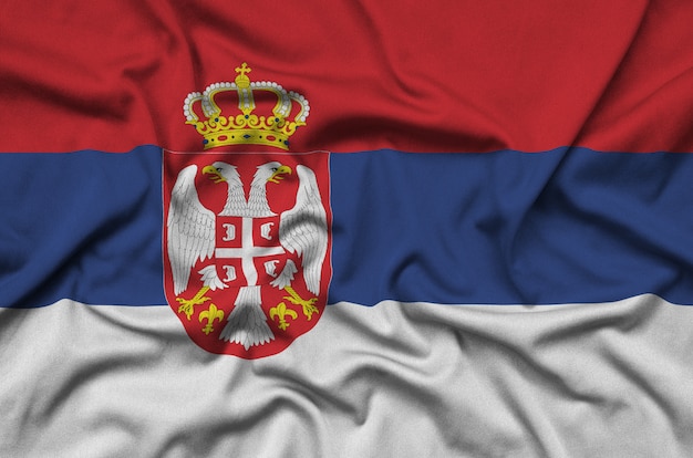 Serbia flag  is depicted on a sports cloth fabric with many folds. 