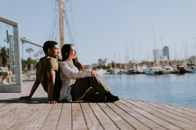 Photo serene afternoon at barcelona marina couple relaxing by tranquil waters