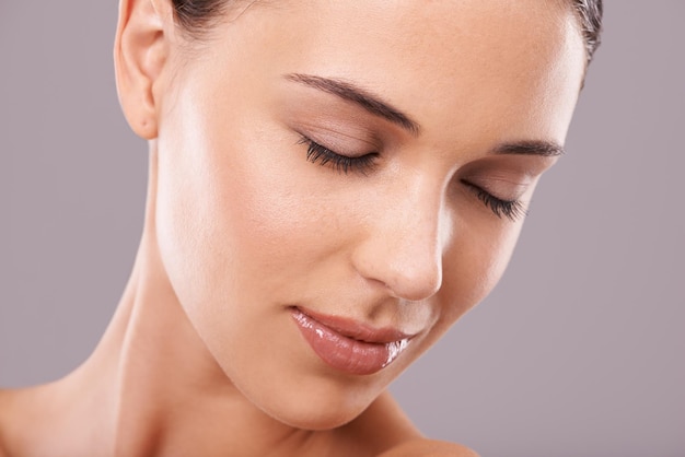 Serene beauty Beauty shot of a beautiful young woman with perfect skin against a gray background