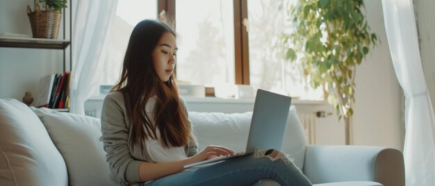 A serene home setting with a young woman focused on her laptop bathed in natural light from the window