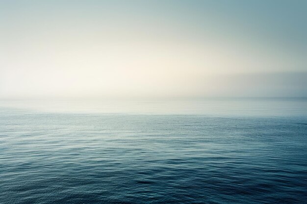 Photo a serene image of calm blue ocean water with a soft misty sky and subtle gradient a subtle gradient of light blue shades creating a soothing atmosphere