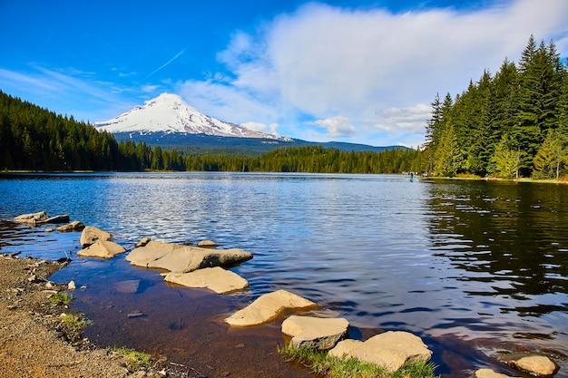 Serene Mount Hood Lake with SnowCapped Peaks and Rocky Shoreline