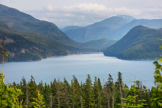 Serene scene by the mountain lake in Canada with reflection of the rocks in the calm water.