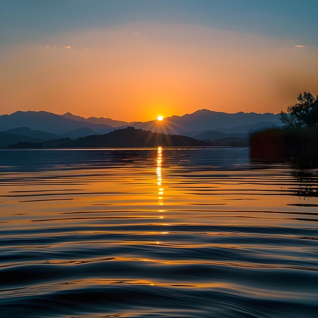 Serene Sunset Over Tranquil Lake with Reflective Water and Mountain Silhouettes