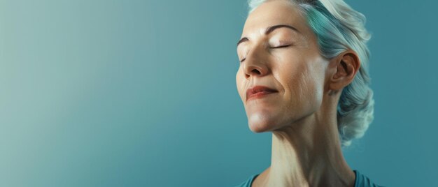 Photo a serene woman with closed eyes enjoys a quiet moment of peace the soft blue background complementing her sense of calm and contentment