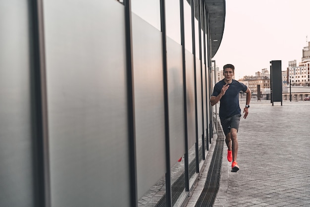 Serious about staying in shape. Full length of young man in sports clothing running 