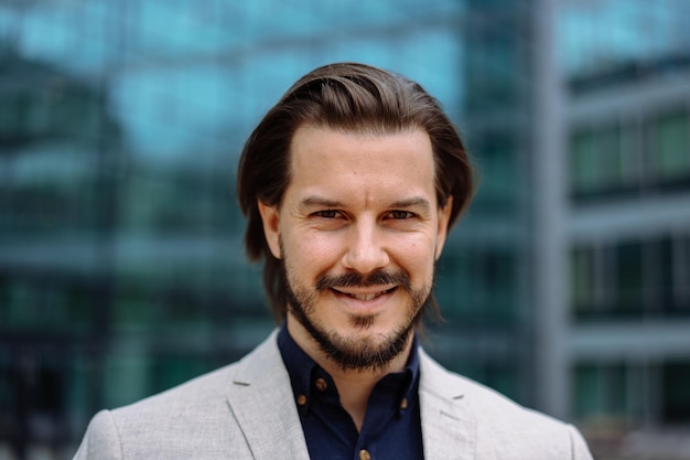 Serious adult businessman in formal wear posing towards modern office building