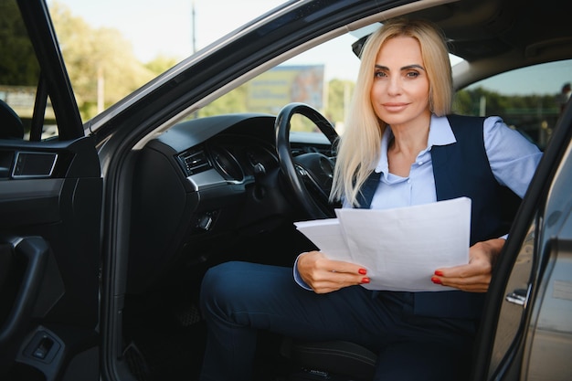 Serious business woman in the car examines important documents