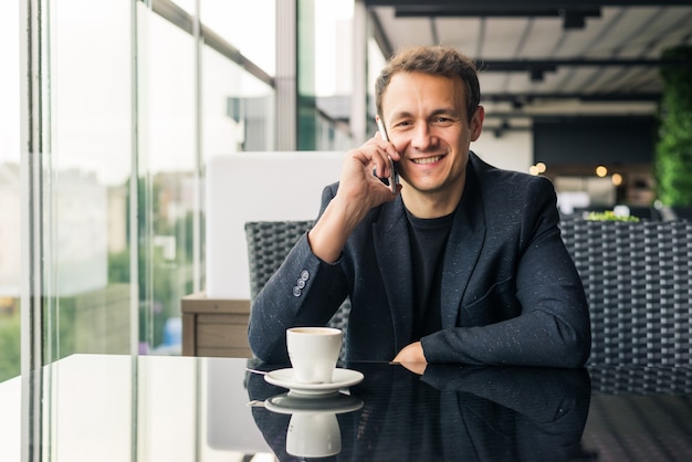 Serious businessman talking on phone in restaurant