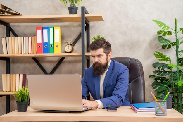 Serious businessman working on laptop at office desk work