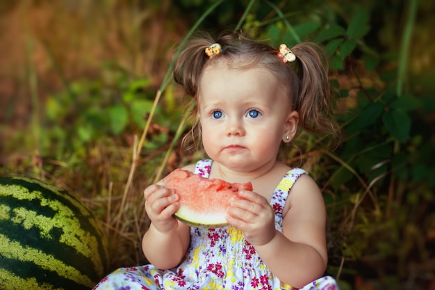 Serious child with juicy watermelon. 