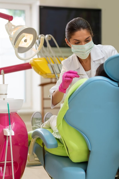 Serious darkhaired woman doctor holding a dental probe