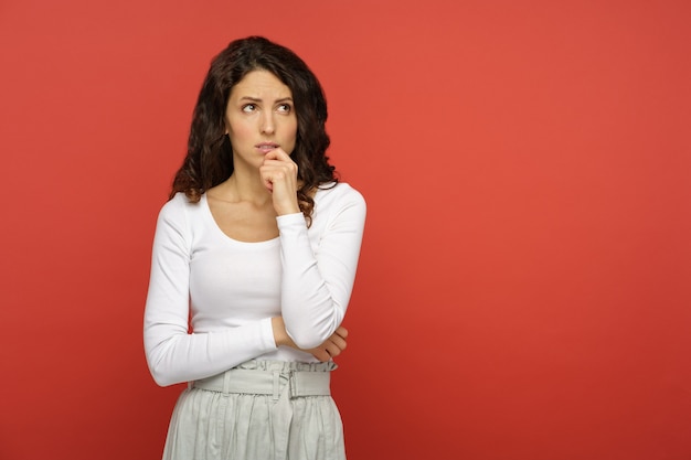 Serious doubtful woman look up think pensive confused young girl concerned upset bite lip in doubts