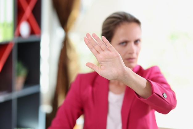 Photo serious female manager showing disagreement gesture while sitting in office