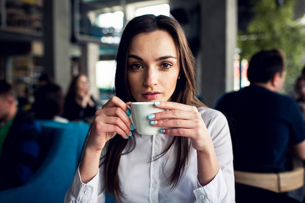 Serious girl having coffee in a bar