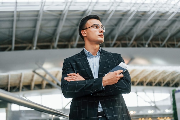 Serious look Young businessman in formal clothes is in the airport at daytime