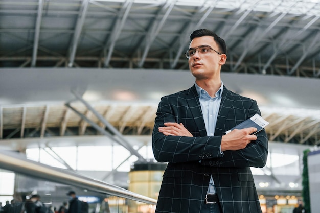 Serious look Young businessman in formal clothes is in the airport at daytime