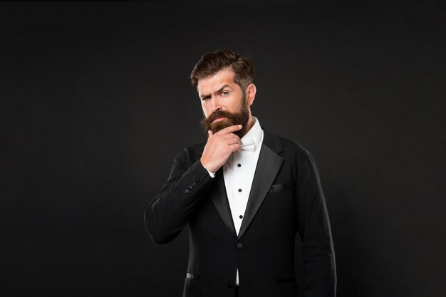 Serious luxury man in tuxedo bow tie gentleman in formalwear on black background formal fashion