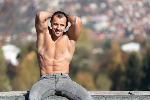 Serious Man Sitting on Old Rooftop and Posing