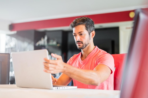 Serious man working on laptop at home