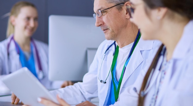 Serious medical team using a laptop in a bright office