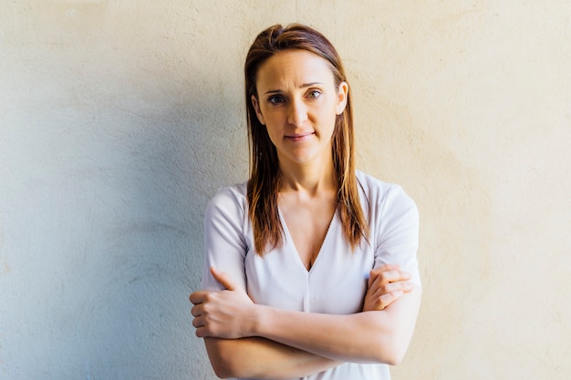 Serious and tired middle aged beautiful young woman with crossed arms.