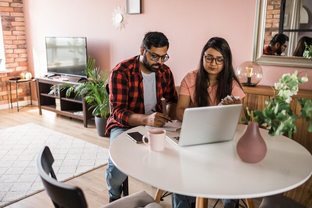 Serious wife and husband planning budget checking finances focused young woman using online calculat